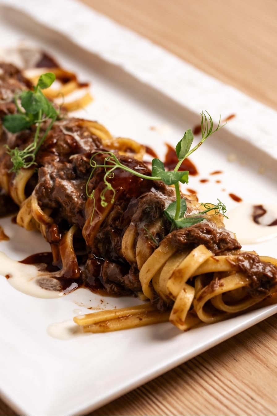 Tagliatelle con rag&ugrave; e pecorino su piatto rettangolare